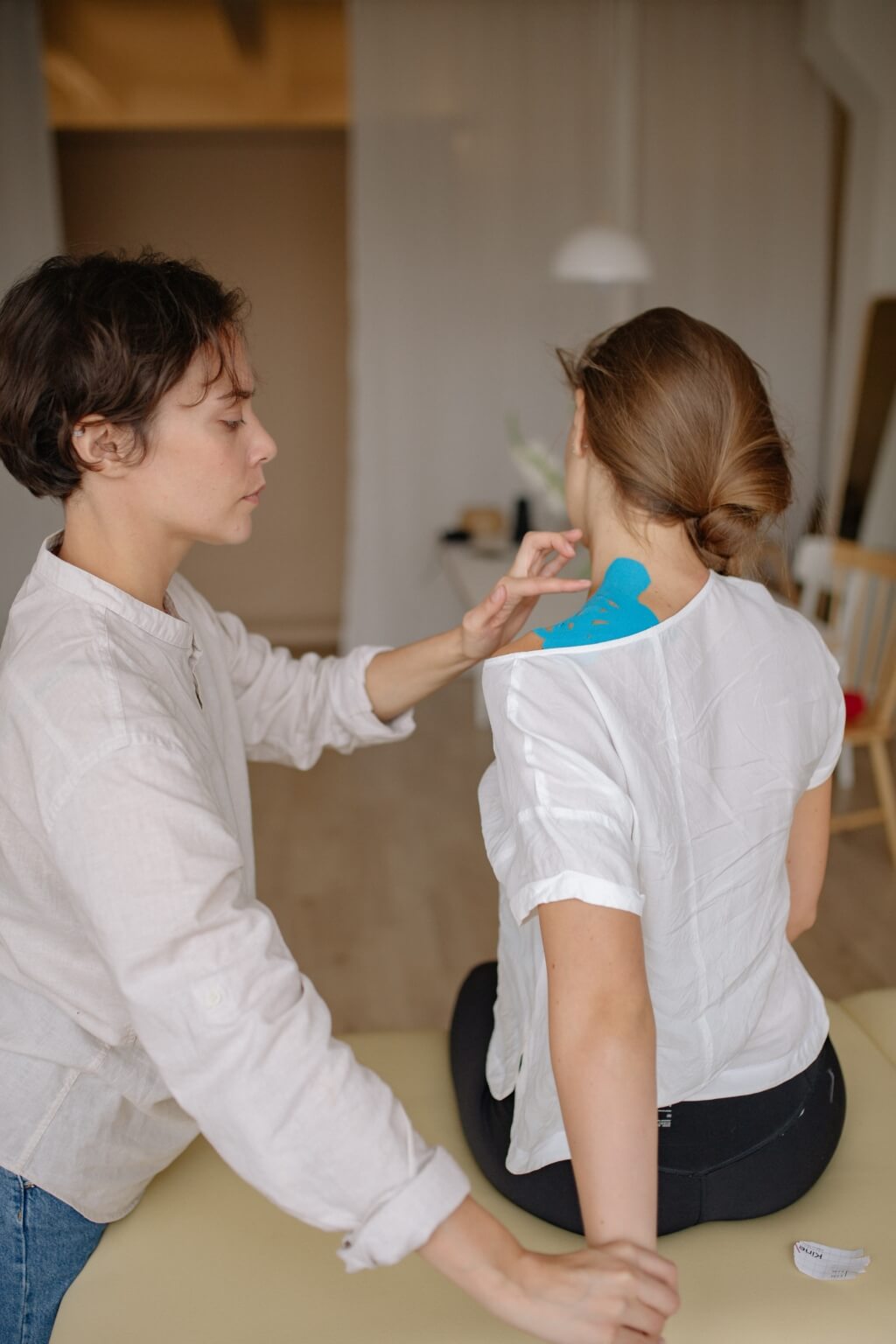 A woman laying a blue strap on another woman